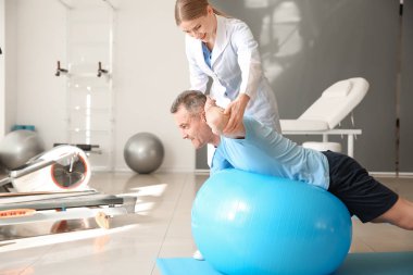 Rehabilitasyon merkezinde olgun hasta ile çalışan fizyoterapist