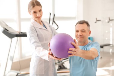 Rehabilitasyon merkezinde olgun hasta ile çalışan fizyoterapist