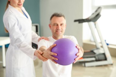 Rehabilitasyon merkezinde olgun hasta ile çalışan fizyoterapist