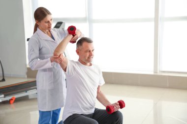 Rehabilitasyon merkezinde olgun hasta ile çalışan fizyoterapist