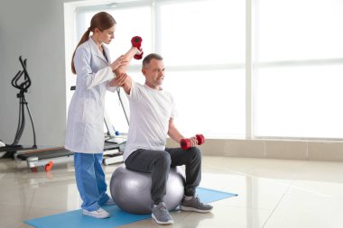 Rehabilitasyon merkezinde olgun hasta ile çalışan fizyoterapist