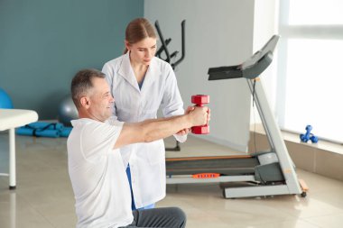 Rehabilitasyon merkezinde olgun hasta ile çalışan fizyoterapist