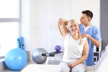 Rehabilitasyon merkezinde olgun hasta ile çalışan fizyoterapist