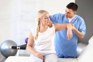 Rehabilitasyon merkezinde olgun hasta ile çalışan fizyoterapist