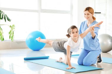 Rehabilitasyon merkezinde küçük kız ile çalışan fizyoterapist