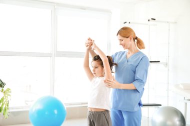 Rehabilitasyon merkezinde küçük kız ile çalışan fizyoterapist