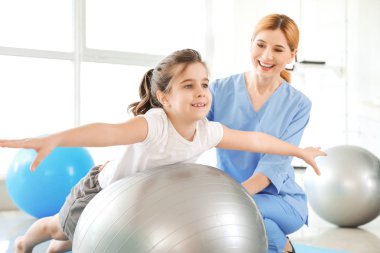 Rehabilitasyon merkezinde küçük kız ile çalışan fizyoterapist