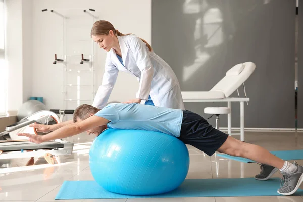 Physiotherapist working with mature patient in rehabilitation center — Stock Photo, Image