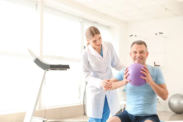 Physiotherapist working with mature patient in rehabilitation center — Stock Photo, Image