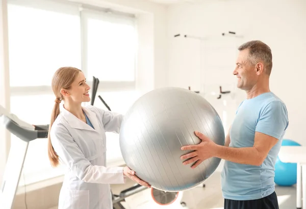 Physiotherapist working with mature patient in rehabilitation center — Stock Photo, Image