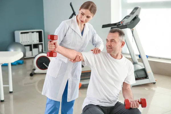 Physiotherapist working with mature patient in rehabilitation center — Stock Photo, Image