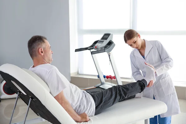 Fisioterapeuta trabajando con paciente maduro en centro de rehabilitación —  Fotos de Stock