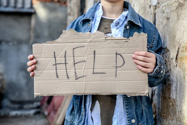 Бездомный мальчик просит помощи на улице — стоковое фото