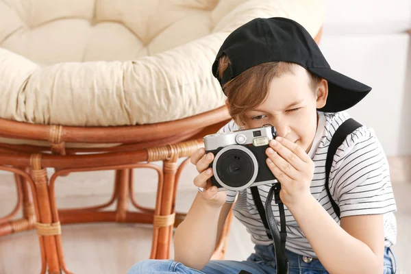 Schattige kleine fotograaf met professionele camera thuis — Stockfoto