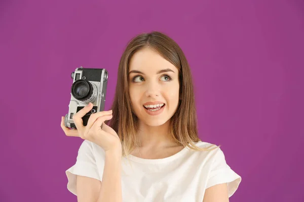 Jonge vrouwelijke fotograaf op kleur achtergrond — Stockfoto