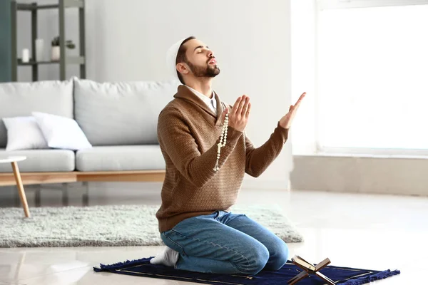 Jovem muçulmano rezando dentro de casa — Fotografia de Stock