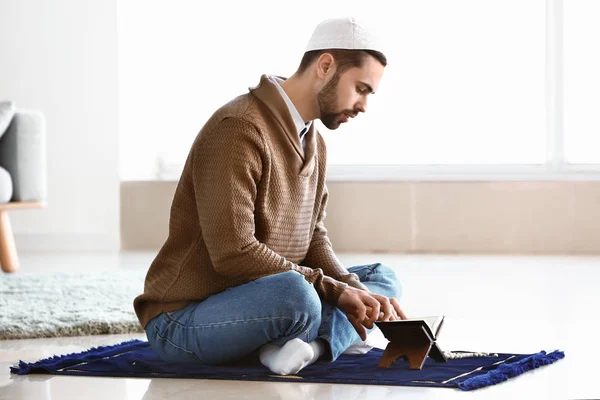 Young Muslim man praying indoors — Stock Photo, Image