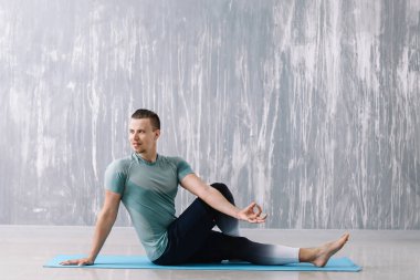 Sportif adam spor salonunda yoga yapıyor.