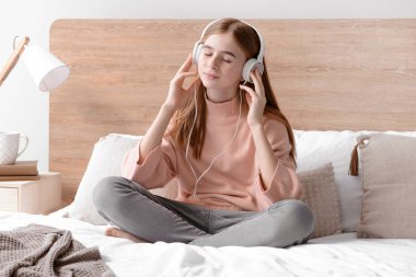 Sevimli genç kız evde yatak odasında müzik dinlerken