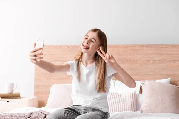 Carino adolescente prendendo selfie in camera da letto a casa — Foto Stock