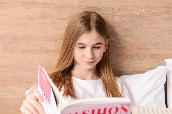 Linda adolescente leyendo revista de moda en el dormitorio en casa — Foto de Stock