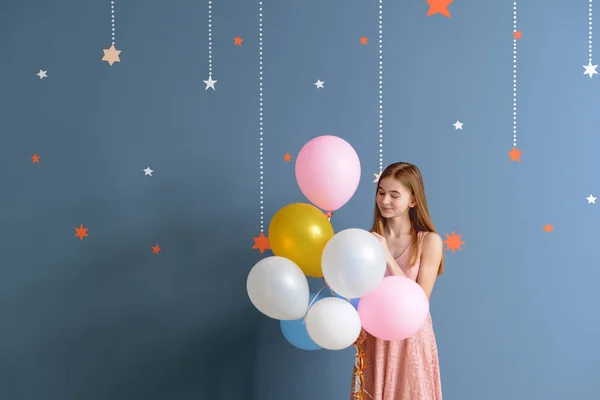 Carino ragazza adolescente con palloncini d'aria su sfondo di colore — Foto Stock