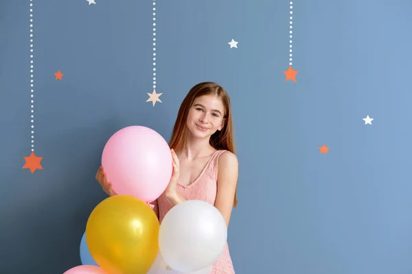 Niedliche Teenager-Mädchen mit Luftballons auf farbigem Hintergrund — Stockfoto