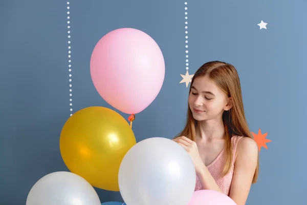 Niedliche Teenager-Mädchen mit Luftballons auf farbigem Hintergrund — Stockfoto