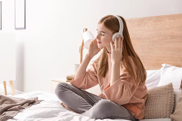 Sevimli genç kız evde yatak odasında müzik dinlerken — Stok fotoğraf