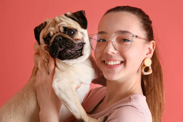 Девочка-подросток с милой собакой-мопсом на цветном фоне — стоковое фото
