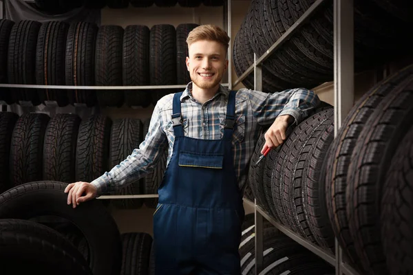 Hombre vendedor en tienda de neumáticos de coche — Foto de Stock