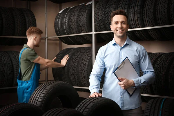 Vendedor masculino na loja de pneus de carro — Fotografia de Stock