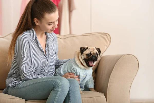 Ragazza adolescente con simpatico cane carlino a casa — Foto Stock