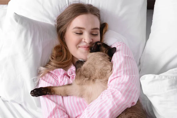 Young woman with cute Thai cat in bedroom — Stock Photo, Image