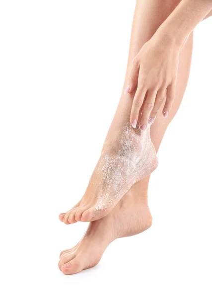 Jovem com esfoliação corporal nas pernas contra fundo branco — Fotografia de Stock