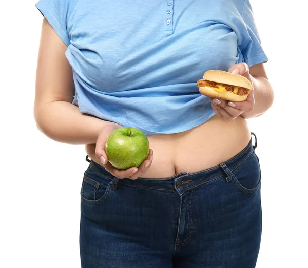 Túlsúlyos nő, alma és hamburger fehér háttérrel. Az egészséges és egészségtelen ételek közötti választás fogalma — Stock Fotó