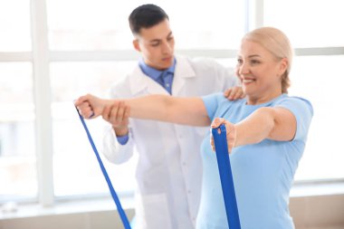 Rehabilitasyon merkezinde olgun hasta ile çalışan fizyoterapist