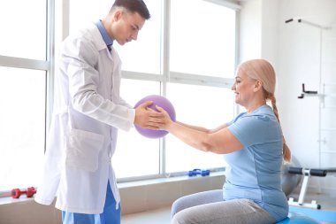 Rehabilitasyon merkezinde olgun hasta ile çalışan fizyoterapist