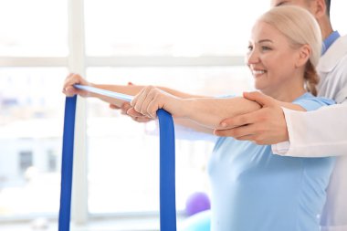 Rehabilitasyon merkezinde olgun hasta ile çalışan fizyoterapist