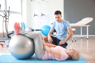 Rehabilitasyon merkezinde olgun hasta ile çalışan fizyoterapist