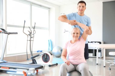 Rehabilitasyon merkezinde olgun hasta ile çalışan fizyoterapist