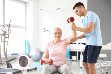 Rehabilitasyon merkezinde olgun hasta ile çalışan fizyoterapist