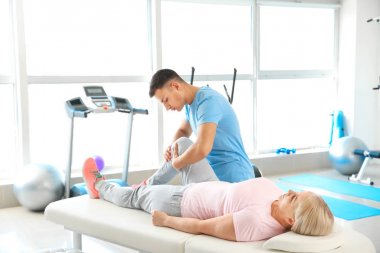 Rehabilitasyon merkezinde olgun hasta ile çalışan fizyoterapist