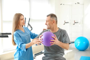 Rehabilitasyon merkezinde olgun hasta ile çalışan fizyoterapist