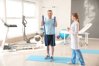 Rehabilitasyon merkezinde olgun hasta ile çalışan fizyoterapist