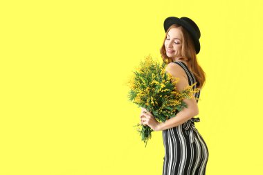 Mimoza buket renk arka plan üzerinde olan güzel kadın