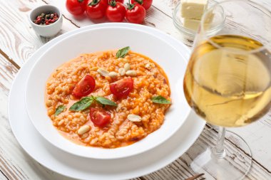 Ahşap masa üzerinde lezzetli risotto ve şarap bir bardak ile Tabak