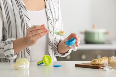 Anne mutfakta bebek nibbler içine taze gıda koyarak