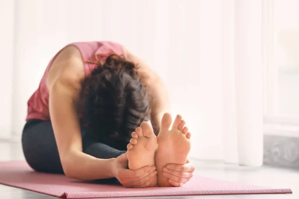 Mujer joven y deportiva practicando yoga en interiores —  Fotos de Stock