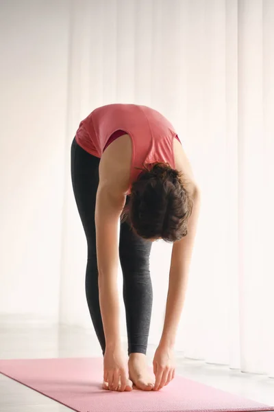 Mujer joven y deportiva practicando yoga en interiores —  Fotos de Stock